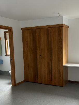 The bedroom features a large built in wardrobe for storage. 